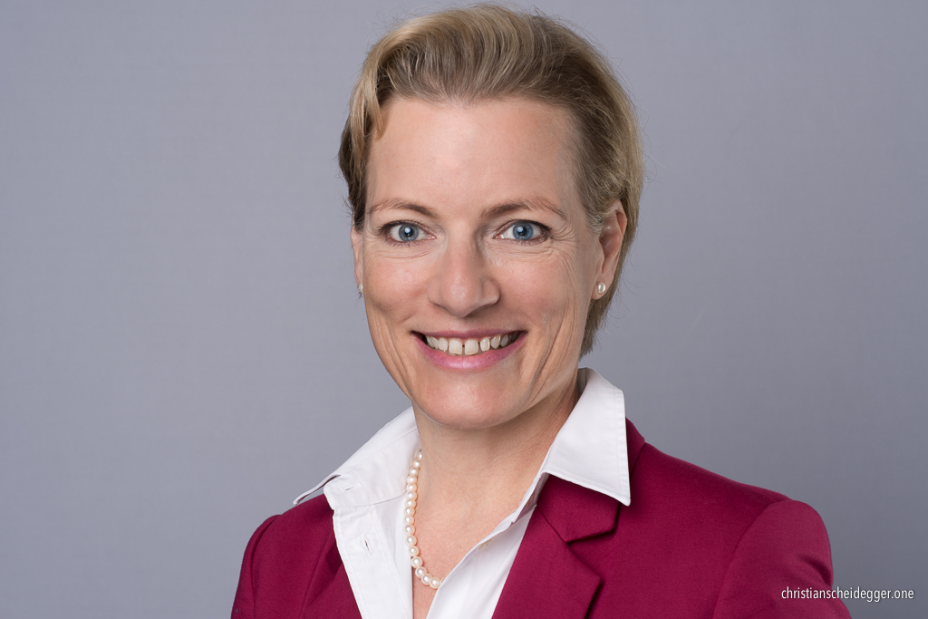 Business Portrait blonde Frau mit weisser Bluse und rotem Blazer